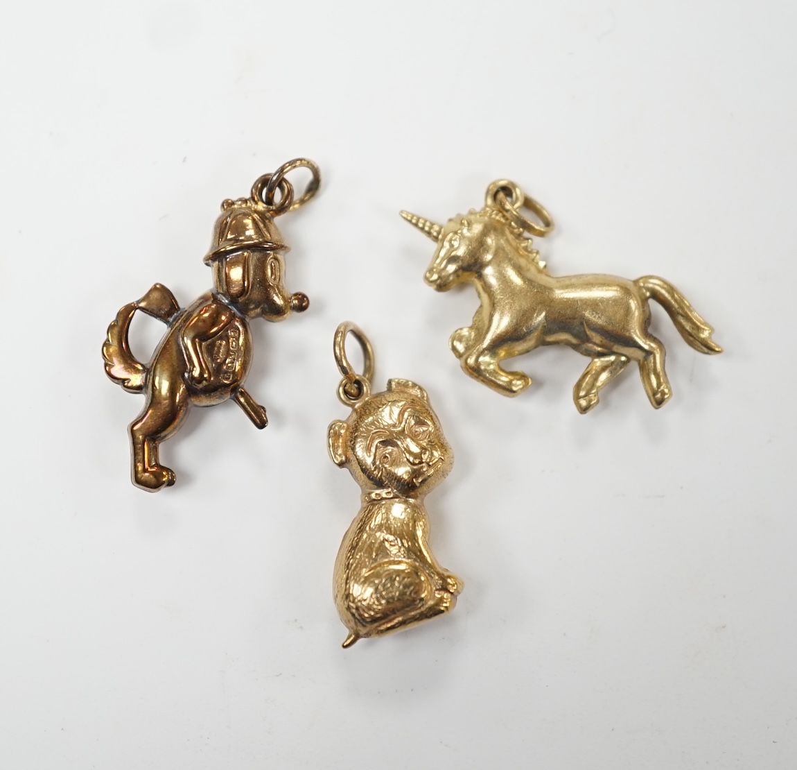 Two 9ct gold charms including 'gun dog', 24mm and a yellow metal unicorn charm. Good condition.